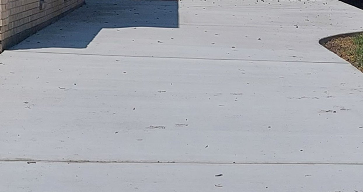Poured concrete walkway beside a brick home