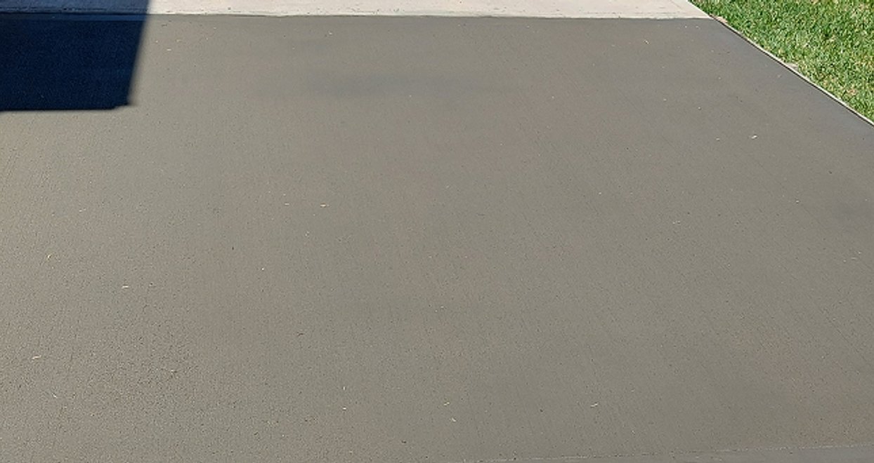 Broom-finished concrete slab next to a lawn