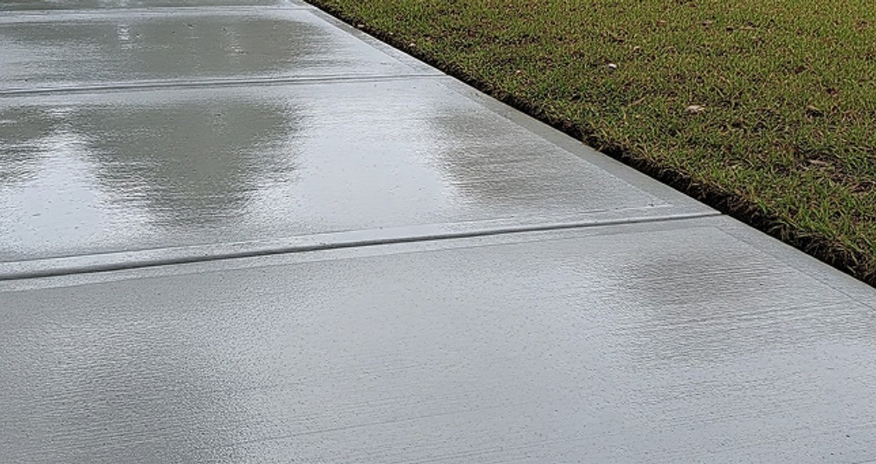 Level concrete sidewalk running beside a lawn