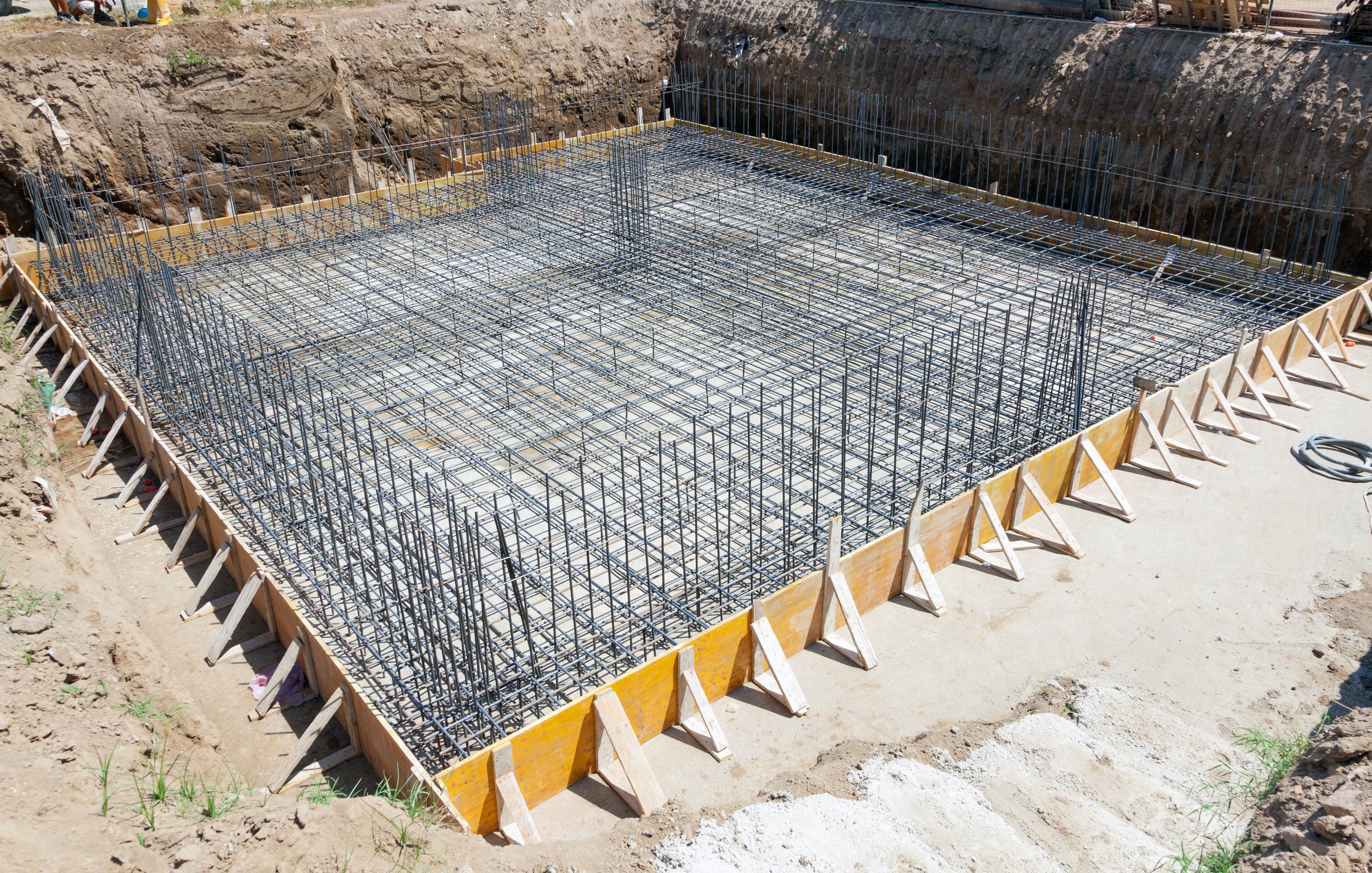 Steel rebar grid set inside wood forms before a concrete foundation pour