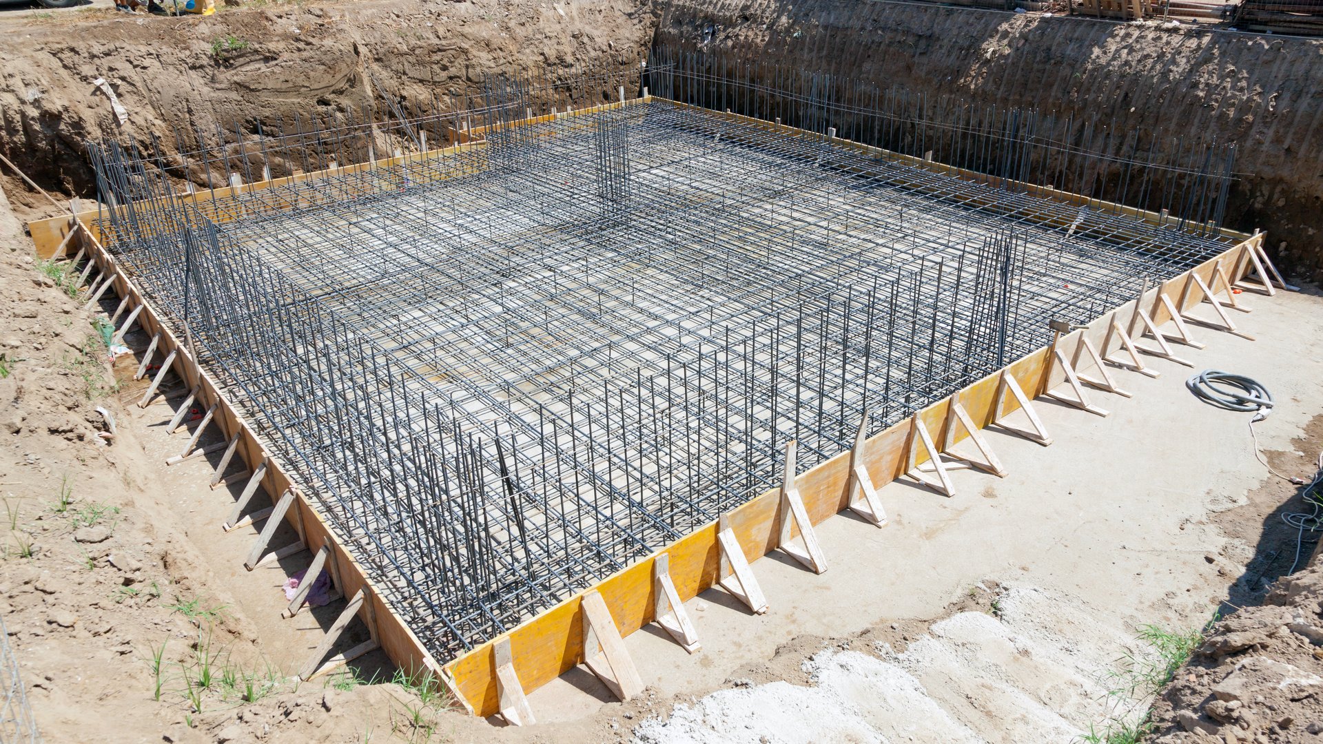 Steel rebar grid inside wood forms, ready for a concrete slab pour