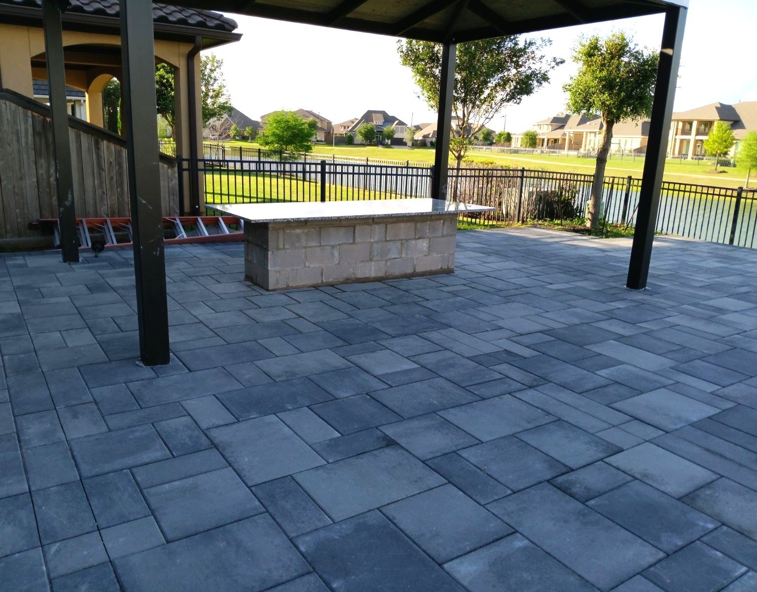 Block island with a stone countertop on a covered paver patio