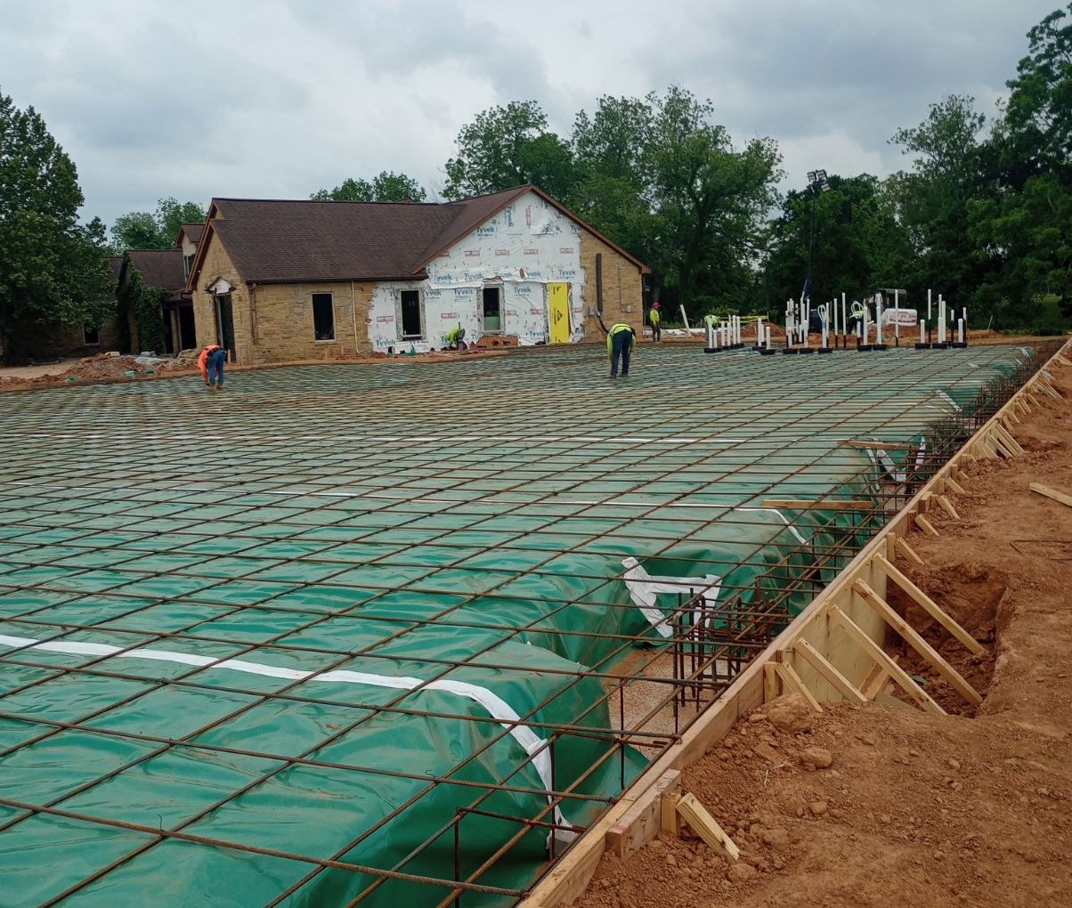 Rebar grid over a plastic vapor barrier on a residential slab foundation before the pour